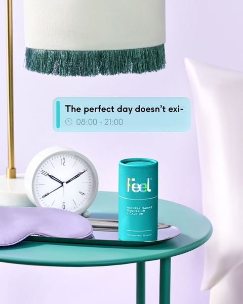A minimalist studio shot of a Natural Marine Magnesium supplement container on a nightstand with a clock and eye mask, implying sleep and wellness.